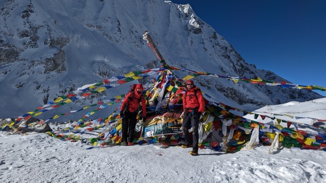A panoramic view of a mountain range in Nepal with a clear blue sky.